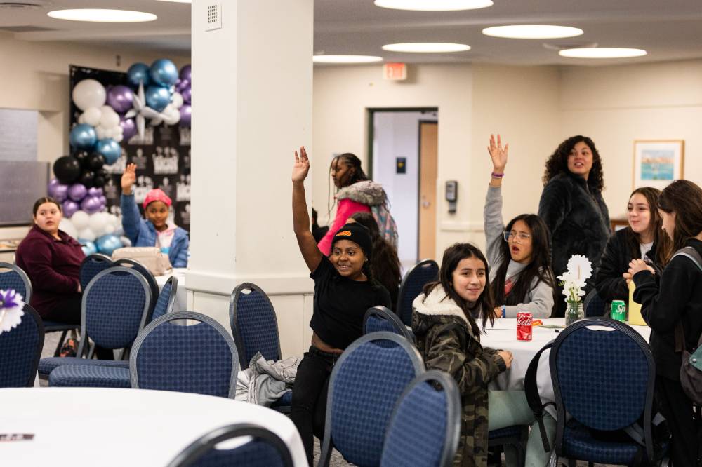 Girls of Color Summit previous event attendees raising hands to answer a question